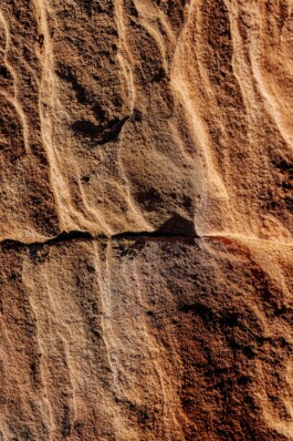 Close-up of layered sandstone texture with warm lighting 